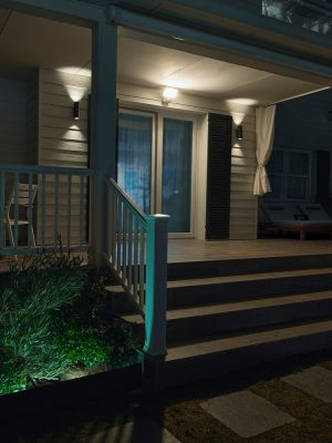 Ab outside porch and backdoors brightly lit with Hue flood light and wall lights shining in white light.