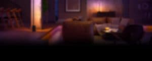 A Philips Hue Signe gradient table lamp washes a wall in purple and pink tones of smart light.