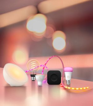 A Philips Hue Signe gradient table lamp washes a wall in purple and pink tones of smart light.