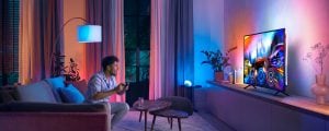 Person playing video game in living room. Spend more, save more.
