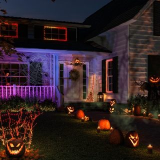 Facciata della casa con decorazioni di Halloween spaventose, come zucche e luci smart colorate