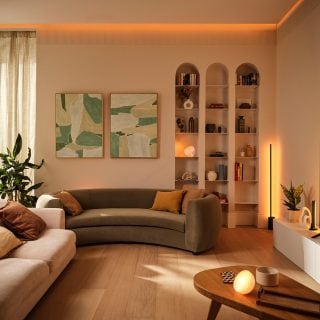 여러 개의 Philips Hue 전등으로 밝힌 거실에서 따뜻하고 아늑한 조명이 빛납니다.