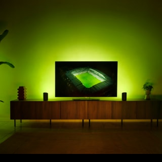 A soccer match displayed on a TV with the Hue Sports Live feature making lights react to the game in tones of Green.