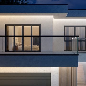 En altan ved soveværelset over en garageport, hvor begge er oplyst af LED strips, der er skjult under loftsprofiler og lyser med kraftigt hvidt lys. 