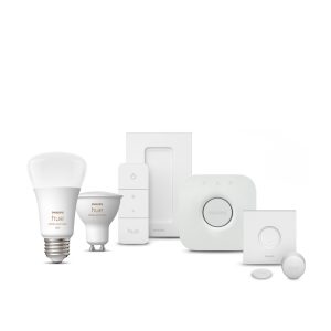 Weiße Lampe eines Hue Starter-Sets für smarte Beleuchtung mit runder Form, kabellosem Dimmer Switch und kompaktem Hub mit matter Oberfläche und sichtbarer Steuerungstaste. 