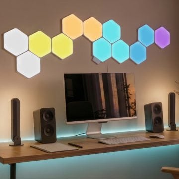 Nanoleaf, hier als sechseckige modulare Wandleuchten-Paneele über einem Desktop-Computer: atmosphärische Philips Hue Light Bars, die eine moderne Home-Office-Wand raffiniert beleuchten.