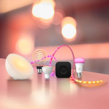 Philips Hue Cashback Aktion – smarte LED-Lampen, Leuchten Lightstrips und Hue Bridge Pro vor warmem Hintergrund
