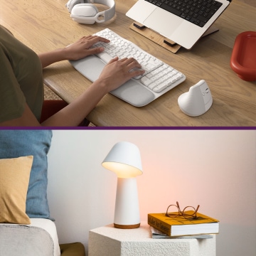 Draufsicht auf Tastatur und Maus auf Schreibtisch; darunter aufgeräumtes Büro mit Holzmöbeln, Regal und Schreibtischlampe.