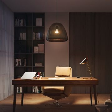 Ein Home Office mit Schreibtisch und Stuhl, beleuchtet von einer smarten Tischleuchte und einer Pendelleuchte in warmen, weichen Tönen.
