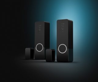 Two black Hue Secure security contact sensors on a black and blue background. 