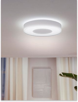 Modern living space illuminated by a Philips Hue circular ceiling light providing bright, white functional lighting.