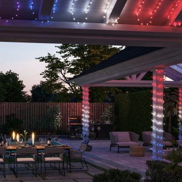 Outside of modern home with string lights set to red, white and blue on patio