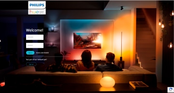Three people on a sofa watch TV in a living room, illuminated by colorful smart lighting that enhances the home entertainment experience.