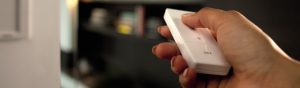 Philips Hue dimmer switch installation - Hand pressing a button on a Hue labeled white dimmer switch