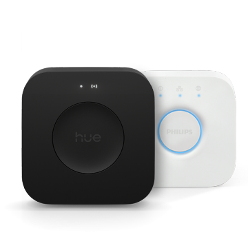 Two compact, square smart lighting bridge devices, one matte black with ""hue"" text, one white with a circular button and blue lights.