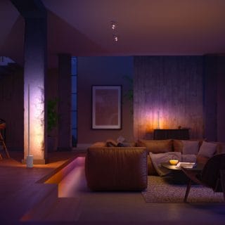 Modern living room with soft ambient glow from smart lighting, highlighting seating area and architectural features in warm tones.