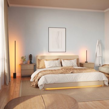 A collection of smart LED string lights installed under a bed frame and on bedside tables, casting adjustable warm light in a bedroom.