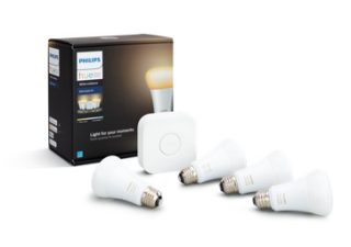 A collection of white smart light bulbs, a square hub device, and a product box labeled ""White ambiance starter kit"" are visible.
