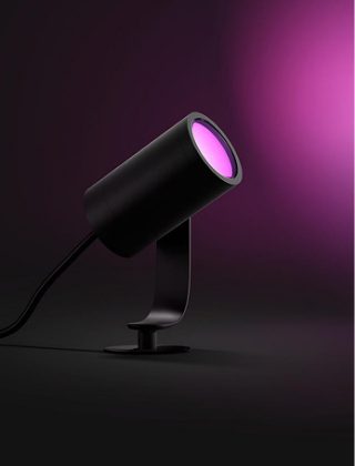 A black Philips Hue Lily spotlight shining with pink light. 