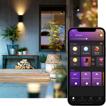 Outdoor patio with smart lighting on the wall, potted plants, and a smartphone displaying backyard lighting control options.