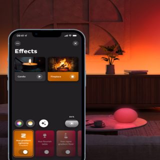 Smart lighting app interface showing ""Effects"" with Candle and Fireplace options, brightness at 84%, lamp emitting gradient light.
