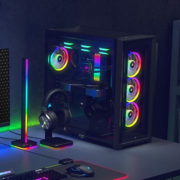 Gaming desktop setup with a multicolor RGB strip light and accessories displaying vibrant lighting effects on and around the desk.