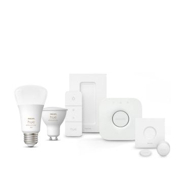 A collection of white smart bulbs, remote controls, a hub, and sensors arranged on a white background.