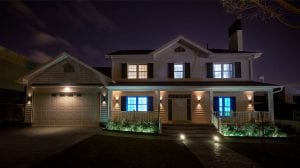 A house at night with illuminated windows in blue and white, creating a soft ambient glow on the porch and garden area.