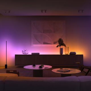 Modern living room with soft ambient purple and orange lighting illuminating a sideboard and wall art, creating a relaxing evening scene.