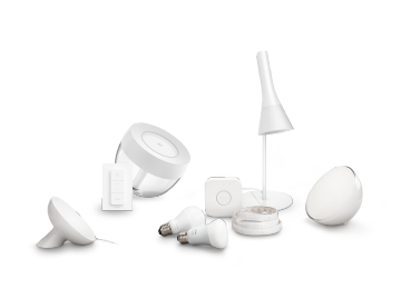 A collection of smart lighting products including bulbs, lamps, a light strip, a remote, and sensors, all in a matching white design.
