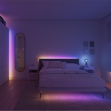 Hue Essential strip lights concealed behind a headboard, wardrobe, and under a bed to create a wall washing effect in blue, pink, and yellow colors of light. 