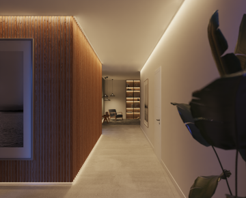 Hallway with soft ambient glow from ceiling light strips, highlighting wood paneling and leading to a living room area.