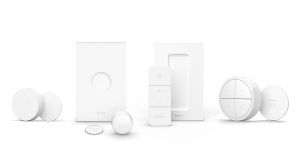 A collection of white smart lighting control switches and accessories, all sharing a minimalist design and similar color.