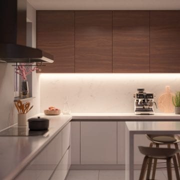 Under-cabinet smart lights installed below wooden kitchen cabinets, illuminating the white countertop and backsplash.