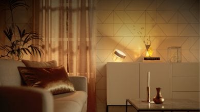 A collection of smart table lamps placed on a cabinet, casting soft light onto a geometric-patterned wall in a living room.