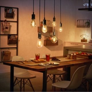 A collection of smart light bulbs suspended above a dining table, emitting adjustable light onto the table and surrounding area.