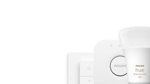 A group of white smart lighting products including a rounded bulb, a square switch with buttons, and a compact square hub.