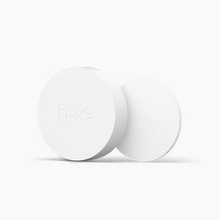 White, round smart button with matte finish, compact design, and ""hue"" text embossed on the front. No visible switches or ports.