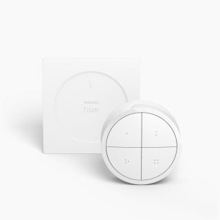 White smart lighting remote control with a circular shape, four buttons, matte finish, and a square wall mount accessory.
