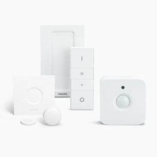 A collection of white smart lighting and security accessories, including switches and sensors, displayed on a plain background.