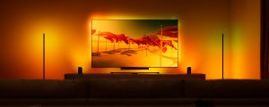 Televisor en una sala de estar moderna, iluminado con luces Hue Play wall washer y Play sincronizadas con el contenido de la pantalla para crear una experiencia de entretenimiento inmersiva y dinámica.
