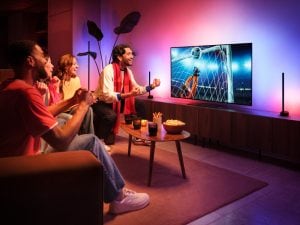 Un groupe d’amis célèbre un but à la télé; la fonction Hue Sports Live fait réagir les lumières en rose et bleu.