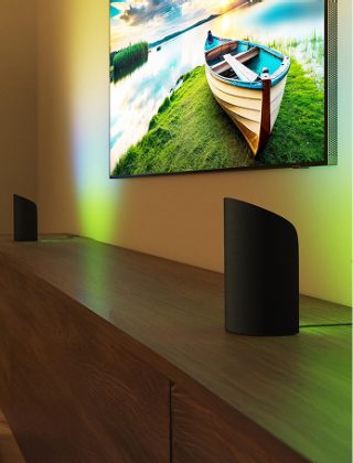 Deux lumières à dégradé lèche-mur Hue Play de part et d’autre d’un téléviseur configuré avec un éclairage de divertissement. 