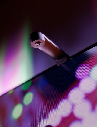 Un appareil de synchronisation d’écran Philips Hue Play avec lentille fisheye fixé sur un téléviseur qui détecte le contenu affiché à l’écran. 