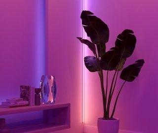 Une bande lumineuse à DEL OmniGlow diffuse une lumière directe dans un dégradé de tons de lumière roses et violets. 