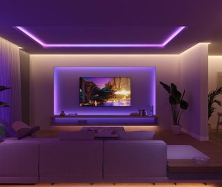 Une configuration d’éclairage de divertissement pour salon et téléviseur éclairée par des bandes lumineuses à dégradé Flux qui brillent dans des tons violets et bleus.