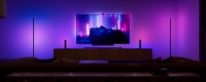 Une télévision dans un salon, avec des lampes qui se synchronisent avec le contenu pour une expérience de divertissement immersive.