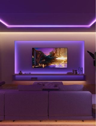 Un salon avec espace TV équipé d’un éclairage de spectacle, illuminé par des rubans lumineux à dégradé diffusant des tons violets et bleus. 
