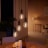 Un ensemble de quatre suspensions équipées d’ampoules Philips Hue Filament, diffusant une lumière blanc chaud.