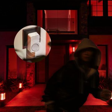 Un intrus s'éloigne d'une porte d'entrée tandis que les lampes de la maison s'allument en rouge et qu'un carillon Hue émet une alerte sonore.